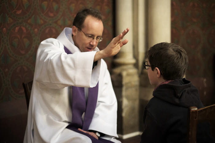 Confession, jeune garçon et prêtre.